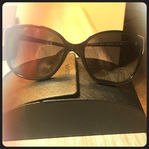 Gold accented Prada sunglasses in case